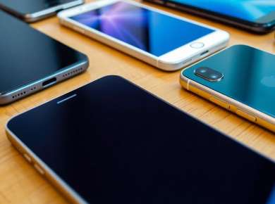 Verschiedene Smartphones auf einem Tisch angeordnet.