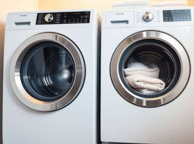 Moderne Waschmaschine in hellen Waschraum mit Handtüchern.