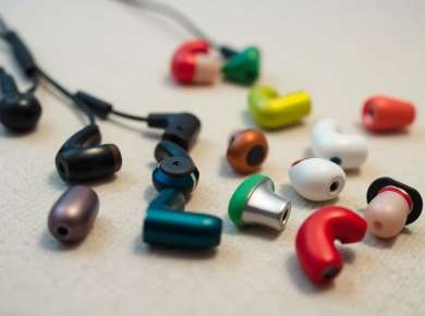 Nahaufnahme verschiedener In-Ear Kopfhörer auf weichem Untergrund.