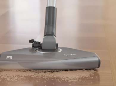 Moderne Staubsauger auf Holzboden in Aktion.
