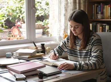 Eine Studentin beim Lernen mit Büchern und Notizen.